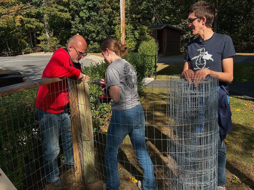 Neighbors of different ages working together on a fence build