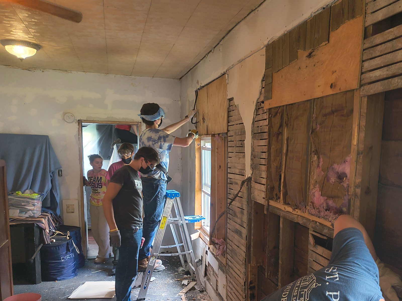Volunteers opening up a wall during a home repair workday